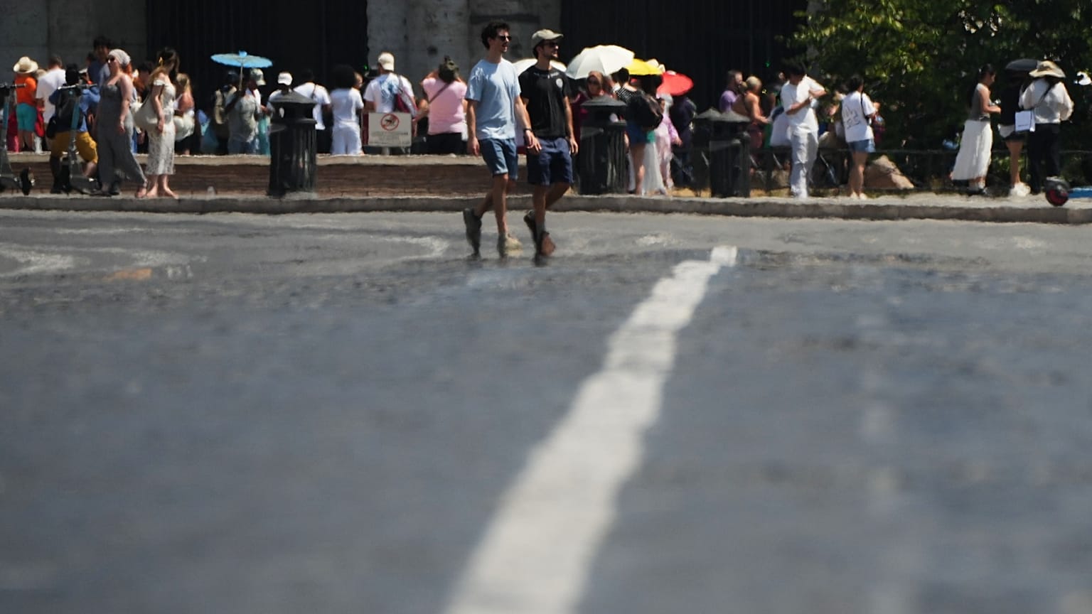 Tourists are blurred by the heat rising from the asphalt as they walk in front of Rome's ancient Colosseum, 1 August, 2026