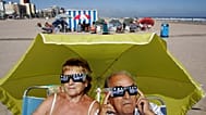 ARCHIVO - Una pareja observa el eclipse anular con gafas especiales en una playa de Gandía, en el este de España, el lunes 3 de octubre de 2005.