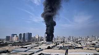 تصاعد دخان أسود من مستودع في المنطقة الصناعية بمدينة الشارقة في الإمارات، عقب تقارير عن ضربات إيرانية استهدفت دبي، 1 آذار 2026.