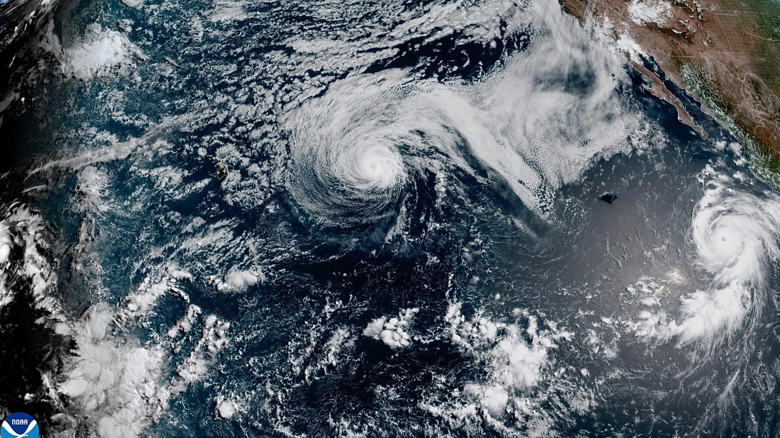 Questa immagine satellitare rilasciata dalla NOAA mostra l'uragano Fausto, al centro, e l'uragano Genevieve al largo della costa sud-occidentale del Messico - 2026