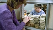 A Muscovite woman puts huge amount of useless money (50 and 100 rubles notes) on the bank counter to exchange them in Moscow on Friday, Jan. 25, 1991