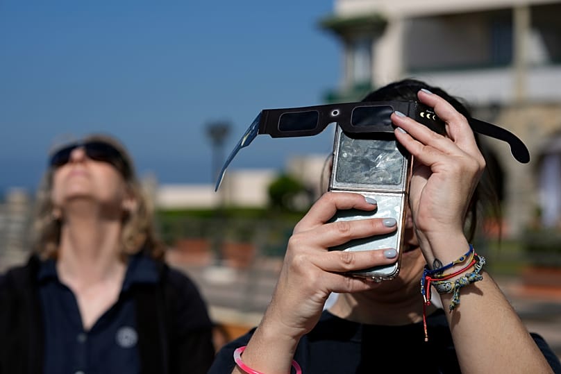Κινητό προστατευμένο με τον φακό από γυαλιά για την έκλειψη