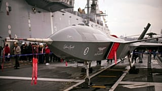 People stand next to an unmanned combat aerial vehicle (UCAV) Bayraktar Kizilelma on board the Turkish amphibious assault ship TCG Anadolu L400, anchored in Istanbul, Turkey, 