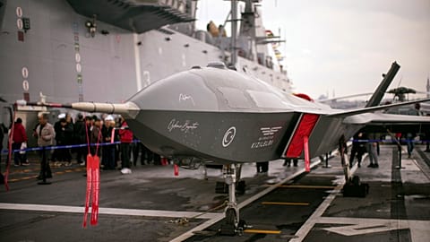 İstanbul'da demirli Türk amfibi hücum gemisi TCG Anadolu L400'de, insanlar insansız savaş hava aracı Bayraktar Kızılelma'nın yanında duruyor.