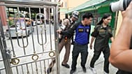 Security officers stand at the gate of a school where deaths and injuries were reported after a shooting in Thailand's Nonthaburi province, 7 August, 2026