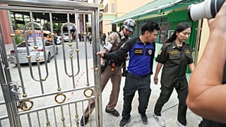 Security officers stand at the gate of a school where deaths and injuries were reported after a shooting in Thailand's Nonthaburi province, 7 August, 2026