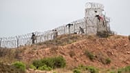 Varias personas pasan junto a una alambrada en la localidad marroquí de Fnideq, al norte del país, mientras intentan cruzar a Ceuta, el viernes 31 de julio de 2026. (Foto AP)