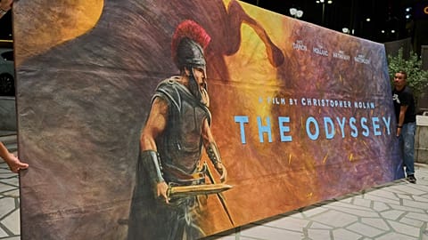 Workers install a hand-painted billboard, painted by Virginia Axioti, for Christopher Nolan's film "The Odyssey," outside Athen's Athinaion cinema, Saturday, July 11, 2026. 