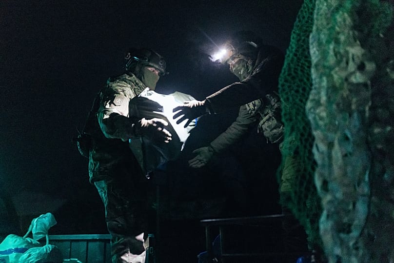 Soldados de la brigada Khartia de Ucrania cargan munición en un dron terrestre de combate destinado al frente en la región de Járkiv, 27 de enero de 2026