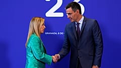 Giorgia Meloni, à esquerda, aperta a mão a Pedro Sánchez à chegada ao segundo dia da Cimeira Europeia, em Granada, Espanha, em 6 de outubro de 2023.