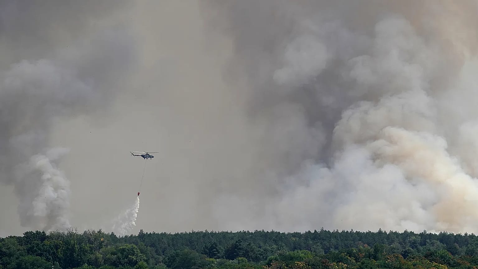 A Serbian Army helicopter battles a fire in Deliblatska Pescara (Deliblato Sands), near the village of Sumarak, 70 kilometers north-west of Belgrade, Serbia, Aug. 7, 2026.