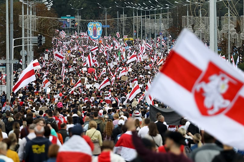 ARCHIVIO: Manifestanti con le vecchie bandiere nazionali bielorusse marciano durante una manifestazione dell'opposizione a Minsk, Bielorussia, il 6 settembre 2020.