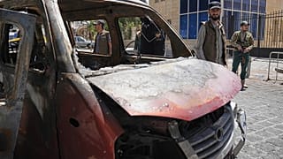 صورة تعبيرية- عناصر أمن سوريون يتفقدون مركبة محترقة بالقرب من فندق "فور سيزونز" عقب وقوع انفجارين هزا المنطقة 
