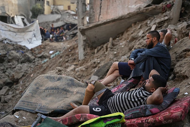 فلسطينيون يتفقدون المباني المدمرة في موقع غارة جوية إسرائيلية على مخيم المغازي للاجئين وسط قطاع غزة، الجمعة 24 يوليو 2026. 
