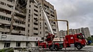 Firefighters put out a fire after a residential building was hit following Russia's drone attack in Kharkiv, Ukraine, Sunday, Aug. 9, 2026