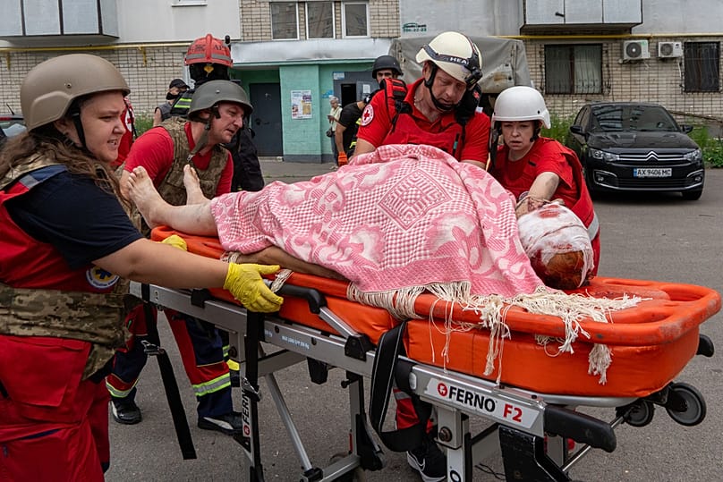 Rescuers evacuate an injured civilian after a residential building was hit following Russia's drone attack in Kharkiv, Ukraine, Sunday, Aug. 9, 2026