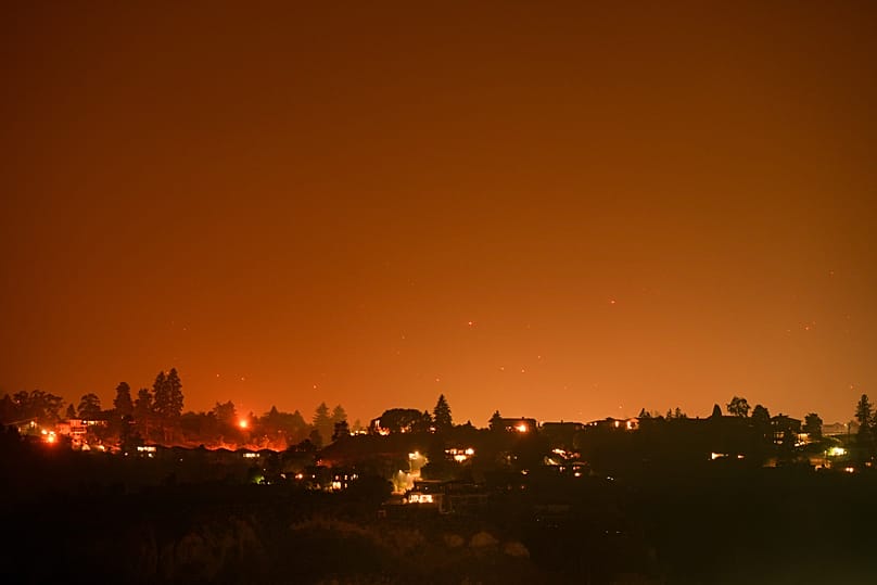 Hot spots from the Bald Range wildfire burn on the mountainside above houses in Summerland, British Columbia, late Saturday, Aug. 8, 2026. 