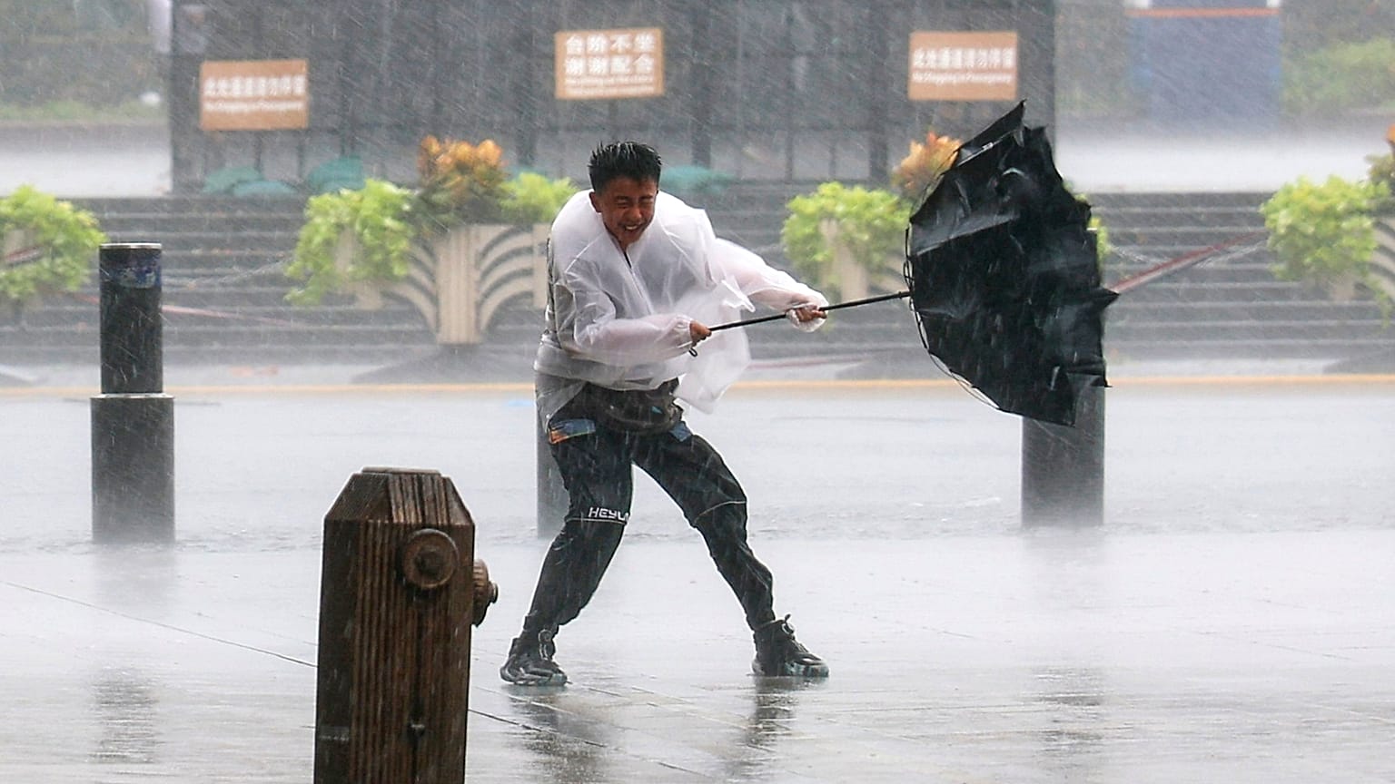 A man fights to hold onto to his umbrella in strong wind and rain ahead of Typhoon Dolphin at Huangpu District of Shanghai, China, Sunday, 9 August 2026.