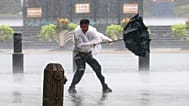 A man fights to hold onto to his umbrella in strong wind and rain ahead of Typhoon Dolphin at Huangpu District of Shanghai, China, Sunday, 9 August 2026.