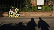 A banner reading in Spanish “Be strong, Messi family” hangs on a cemetery fence beside a floral wreath during the funeral of soccer player Lionel Messi’s father, Jorge Messi