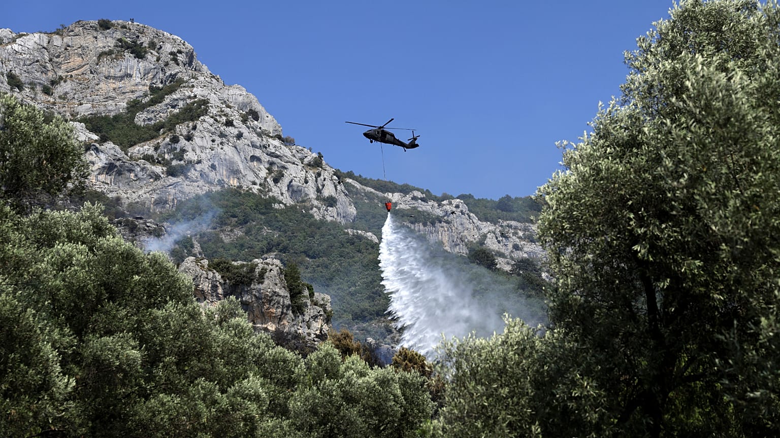 Un elicottero antincendio al lavoro per spegnere un incendio boschivo a Kruja, a nord di Tirana, in Albania, domenica 9 agosto 2026