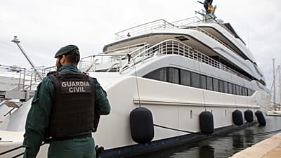 Na archiwalnym zdjęciu z kwietnia 2022 r. funkcjonariusz Guardia Civil pilnuje jachtu w porcie w Palmie.