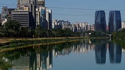 Cyclists ride along a cycle path by the Pinheiros River in São Paulo