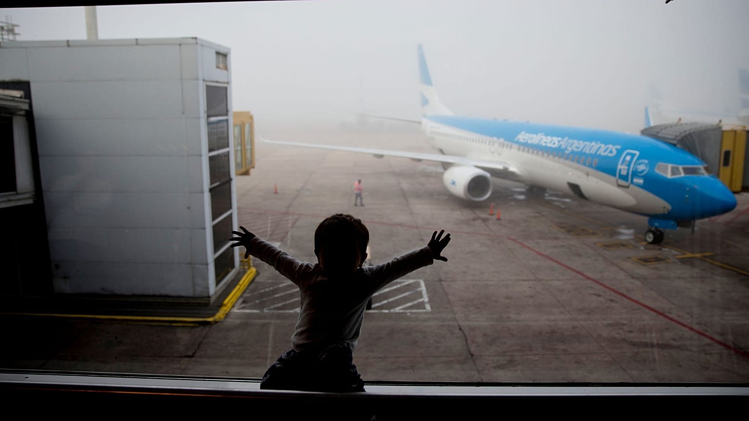 A child watches a plane at the Jorge Newbery airport in Buenos Aires