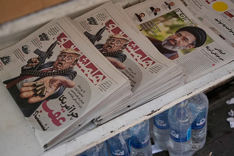 Tahran'da bir bayide sergilenen, ABD Başkanı Donald Trump'ın karikatürünün ve İran'ın Ayetullahı Mücteba Hamaney'in portresinin yer aldığı İran gazeteleri, 27 Temmuz 2026