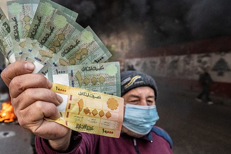 رجل يحمل أوراقاً نقدية لبنانية خلال احتجاج أمام مصرف لبنان في بيروت، 25 كانون الثاني/يناير 2023.