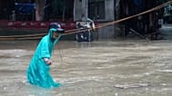 A man crosses floodwaters caused by heavy seasonal monsoon rains at Bagong Silangan village in Quezon city, 10 August, 2026
