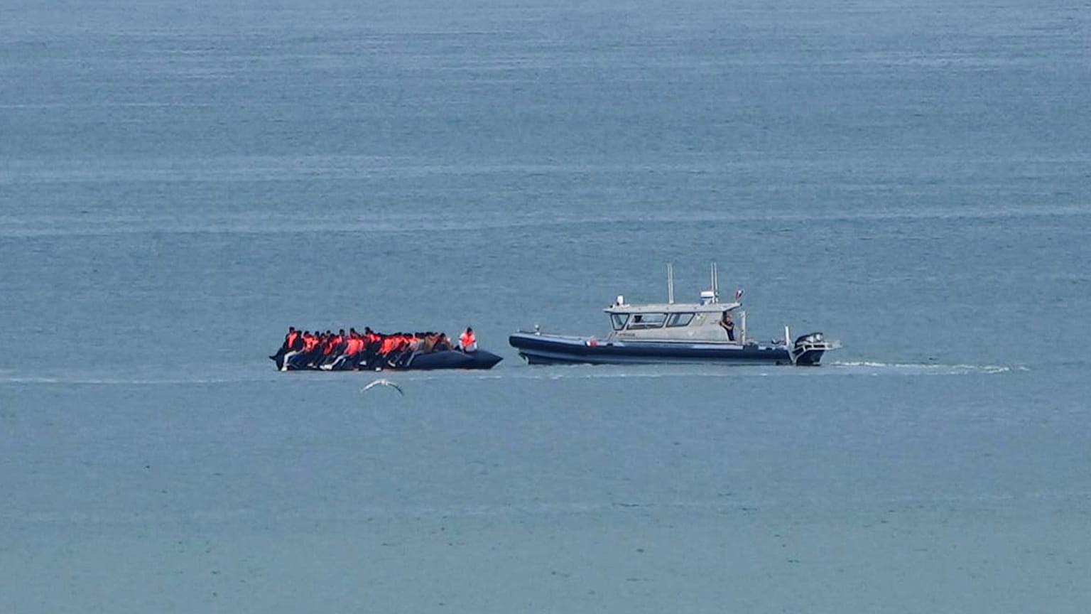 A boat thought to carry migrants is escorted by a vessel from the French Gendarmerie Nationale in the English Channel off Wimereux beach, 4 September, 2024