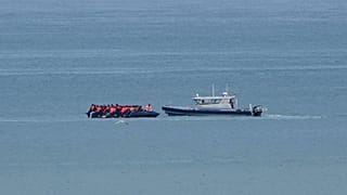 A boat thought to carry migrants is escorted by a vessel from the French Gendarmerie Nationale in the English Channel off Wimereux beach, 4 September, 2024