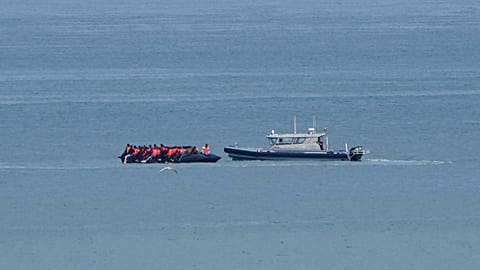Un barcone con migranti a bordo viene scortato da una motovedetta della Gendarmerie francese nel Canale della Manica, al largo di Wimereux, 4 settembre 2024