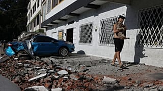 A man carries his dog after an earthquake struck Cali, 10 August, 2026