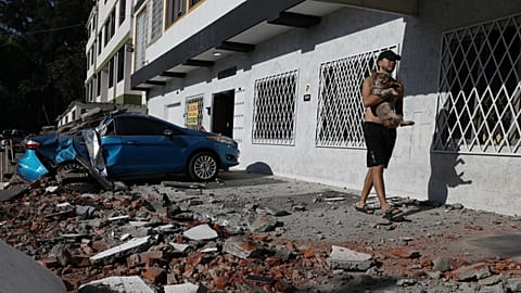 A man carries his dog after an earthquake struck Cali, 10 August, 2026