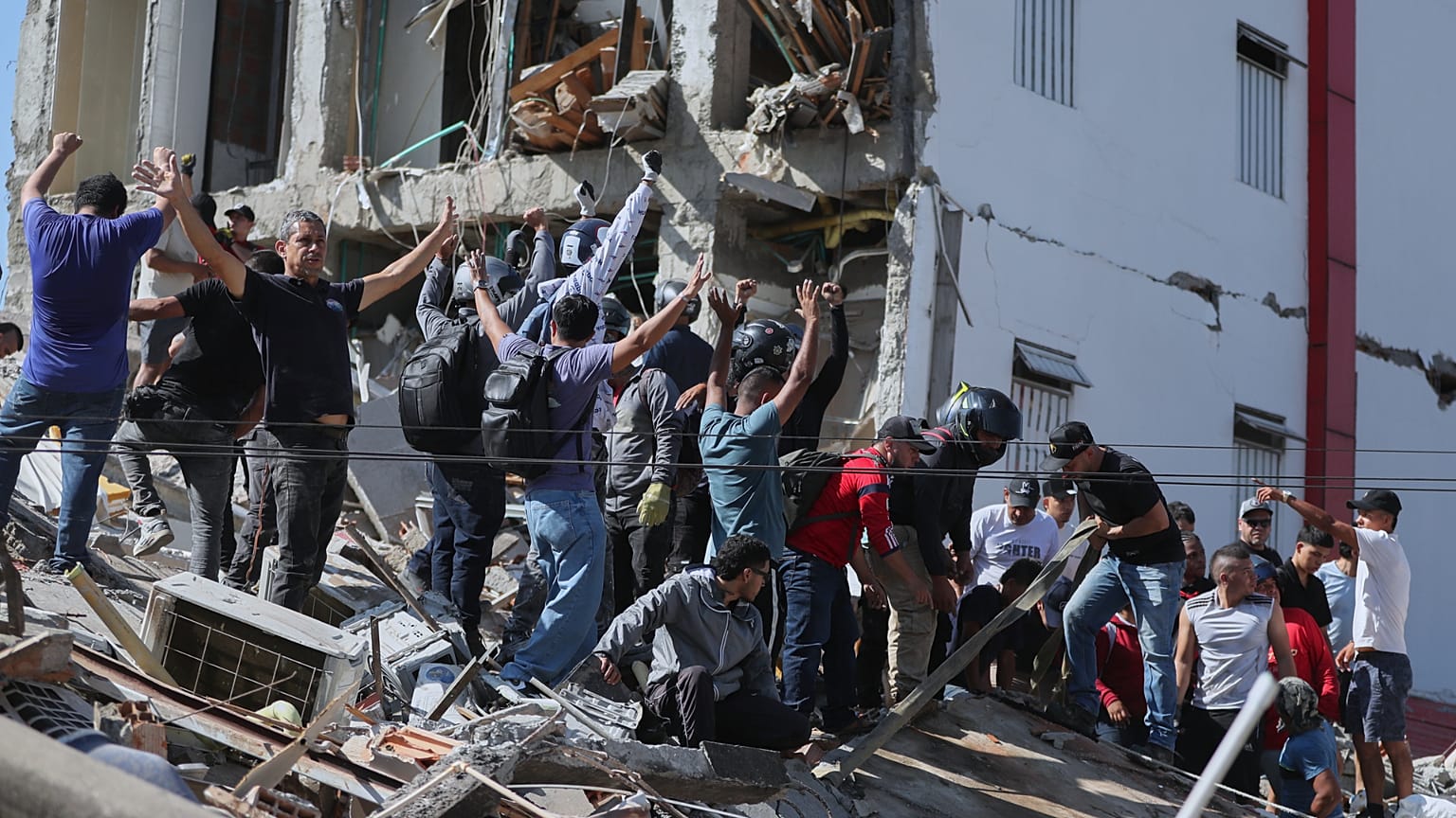 Residenti e soccorritori cercano tra le macerie di un edificio crollato dopo il terremoto che ha colpito Cali, in Colombia, lunedì 10 agosto 2026.