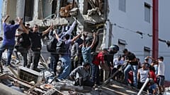 Residenti e soccorritori cercano tra le macerie di un edificio crollato dopo il terremoto che ha colpito Cali, in Colombia, lunedì 10 agosto 2026.