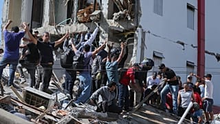 Residenti e soccorritori cercano tra le macerie di un edificio crollato dopo il terremoto che ha colpito Cali, in Colombia, lunedì 10 agosto 2026.