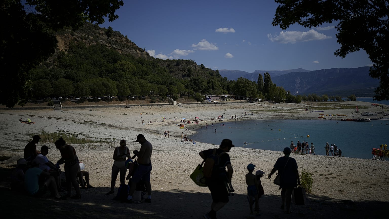 Des baigneurs cherchent de l'ombre sur les rives des Gorges du Verdon, dont le niveau baisse, dans le sud de la France, ce mardi 9 août 2022.