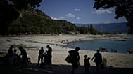 Des baigneurs cherchent de l'ombre sur les rives des Gorges du Verdon, dont le niveau baisse, dans le sud de la France, ce mardi 9 août 2022.