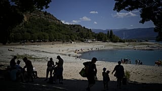 Des baigneurs cherchent de l'ombre sur les rives des Gorges du Verdon, dont le niveau baisse, dans le sud de la France, ce mardi 9 août 2022.