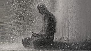 A person cools off at Trocadero fountain near the Eiffel Tower during a heat wave in Paris, 24 June, 2026