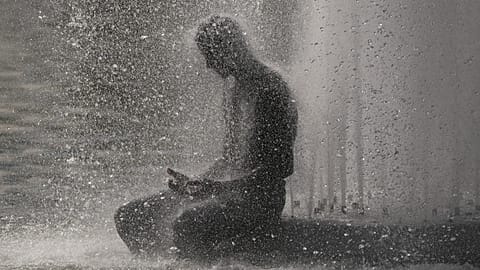 A person cools off at Trocadero fountain near the Eiffel Tower during a heat wave in Paris, 24 June, 2026