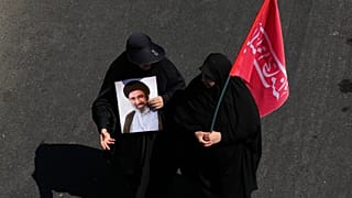 امرأتان إيرانيتان تحمل إحداهما صورة المرشد الأعلى مجتبى خامنئي، والأخرى علماً خلال مراسم الأربعين في طهران، 4 آب 2026.
