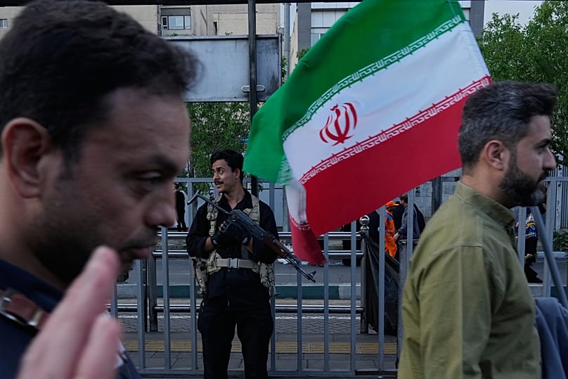 رجل يحمل العلم الإيراني خلال تجمع مؤيد للمرشد الأعلى مجتبى خامنئي في طهران، 29 نيسان 2026.