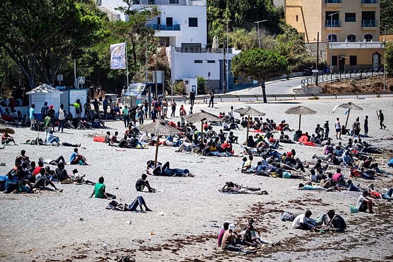 Migrants who crossed into Spain from Morocco gather on a beach in the Spanish enclave of Ceuta, 2 August, 2026