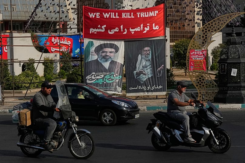Vehicles drive past a banner reading in English and Farsi, "We will kill Trump" in Tehran, 10 August, 2026