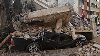 Un vehículo quedó aplastado bajo los escombros tras el terremoto que sacudió Cali, Colombia, el lunes 10 de agosto de 2026. (Foto AP/Juan Díaz)