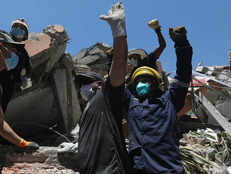 La gente pide silencio durante la búsqueda de supervivientes tras el terremoto que sacudió Cali, Colombia, el lunes 10 de agosto de 2026. (Foto AP/Santiago Saldarriaga)